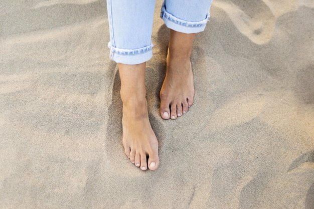 high-angle-woman-feet-sand-beach_23-2148629771